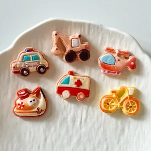 Detailed view of colorful cartoon transportation resin charms for DIY crafts and accessories