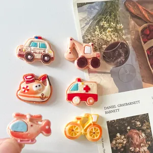 Detailed view of colorful cartoon vehicle resin charms like police cars and excavators
