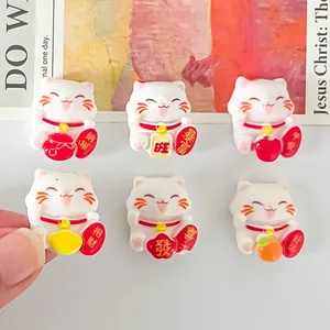 Detailed view of six cute white Maneki-neko resin charms for DIY phone case and shoe decoration