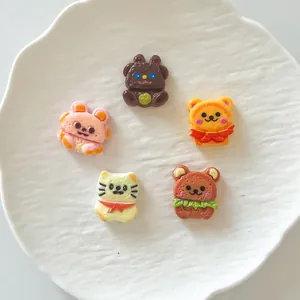 Nahaufnahme von Mini-Cartoon-Tierkeks-Harzanhängern für DIY-Handyhüllen-Bastelarbeiten