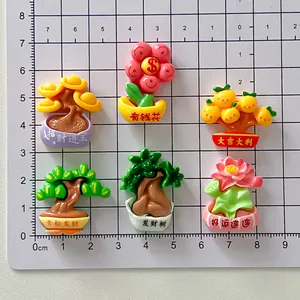 Detailweergave van zes geluksplanten hars bedeltjes op een meetrooster voor DIY projecten