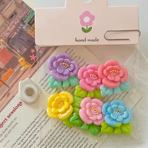 Detalle macro de coloridas flores de resina DIY en bolsas de embalaje rosa.
