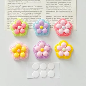 Close-up view of colorful glossy resin flowers with adhesive dots for DIY craft accessories