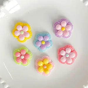 Detailed macro shot of colorful shiny five-petal flower resin charms for DIY craft projects
