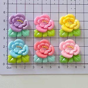 Vista detallada de accesorios de flores de durazno de resina de colores en tabla métrica