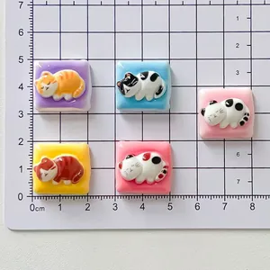 Detailed size view of cute cartoon sleeping cat resin accessories on a grid mat