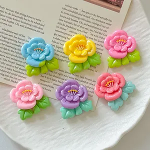 Primer plano de dijes de flores de durazno de resina colorida para manualidades y decoración
