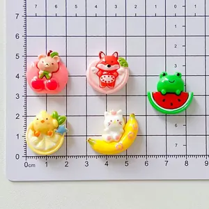 Detailed view of various cute resin animal charms on a measurement grid for DIY projects