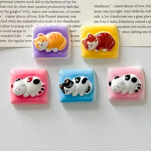 Close-up of cute sleeping cat resin charms in various pastel colors for DIY crafts handmade
