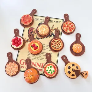 Varietà di accessori alimentari in resina in miniatura su minuscole tavole di legno