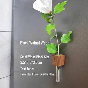 Close-up of a black walnut wood block holding a glass test tube vase with a fresh flower