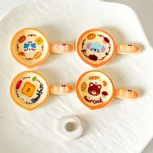 Close-up of colorful resin frying pan magnets with cute cartoon animal character designs.