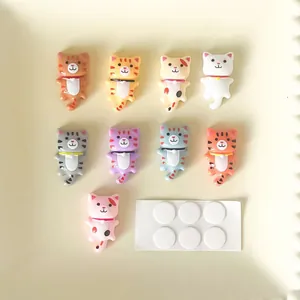 Vue détaillée de breloques chat en résine avec pastilles adhésives pour pinces à cheveux DIY.