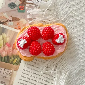 Makrodetail eines süßen 3D-Harz-Himbeer-Toast-Kühlschrankmagneten mit rosa Creme