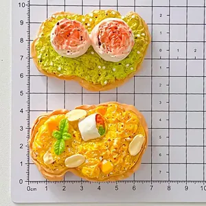 Nahaufnahme von Miniatur-Toast-Harzmagneten auf einer Zentimeter-Skala-Gittermatte