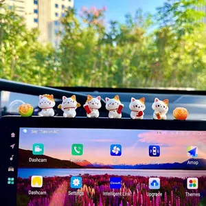 Macro view of six cute mini Maneki-neko lucky cat figurines on a car center console.