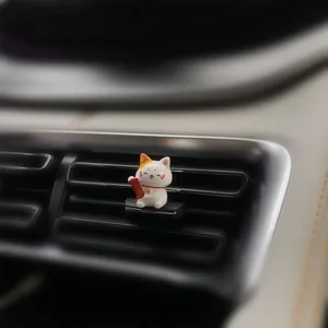 Detailed macro shot of a cute Maneki Neko lucky cat air vent clip car decoration
