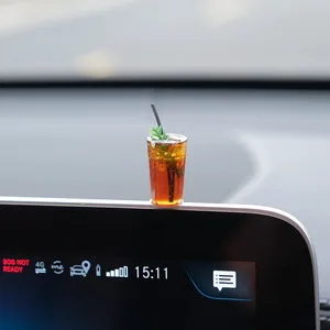 Close-up of a miniature iced coffee car dashboard ornament with realistic resin detail.