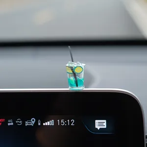 Detailed view of a miniature blue soda drink car ornament placed on a vehicle screen