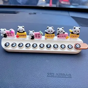 Detailed view of a cute panda-themed car temporary parking phone number plate on a dashboard