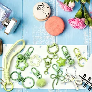 Close-up detail of various green DIY keychain accessories including star and bow charms