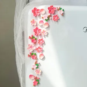 Dettaglio dei magneti da frigo in resina con fiori di pesco 3D su fondo bianco