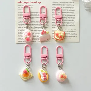 Set of six cute simulation food keychains with pink lobster clasps on decorative paper