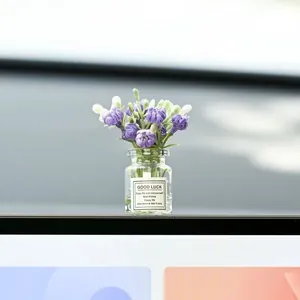 Small car dashboard vase with purple artificial flowers and inspirational 'Good Luck' label.