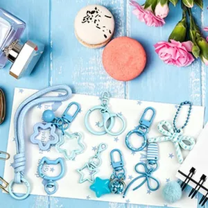 Macro view of various blue DIY keychain accessories including star and bow pendants