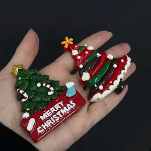 Detailansicht von zwei 3D-Harz-Weihnachtsbaum-Kühlschrankmagneten in der Hand gehalten.