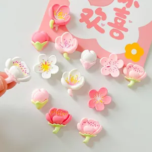 Detailed macro shot of assorted pink and white resin cherry blossom patches for DIY crafts