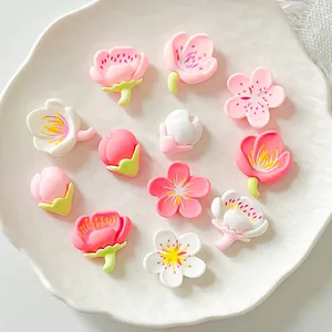 Detailed macro view of assorted pink and white resin cherry blossom charms for DIY crafts