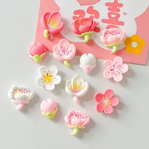 Assorted pink and white resin cherry blossom charms for DIY crafts and accessories.