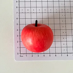 Detailed size measurement of a realistic red apple fridge magnet displayed on a grid board