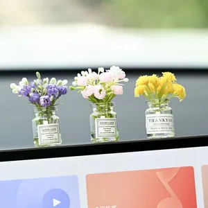 Close-up of three miniature glass flower vases with colorful artificial blooms for cars