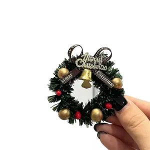 Magnat de frigo couronne de Noël miniature avec cloche Merry Christmas et baies.