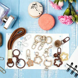 Detail view of various DIY keychain charms and colorful metal accessories on blue background