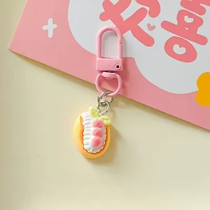 Detailed view of a cute pink dessert food play keychain with realistic cream and strawberry