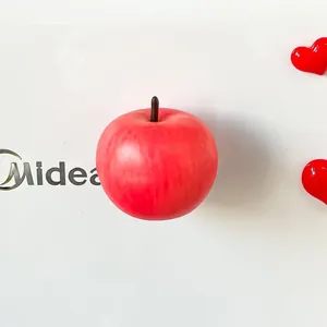 Detailed close-up view of a realistic red apple fridge magnet on a white surface