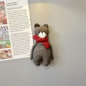 Calamita da frigo con coniglio in tessuto grigio e sciarpa rossa su fondo minimale
