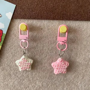 Détail de charmants pendentifs de sac en résine gaufre étoilée avec fermoirs en métal rose