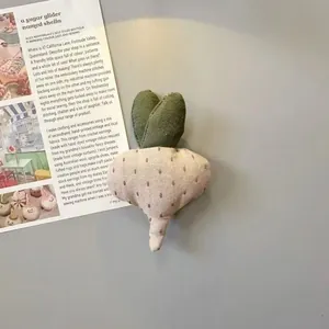 Calamita da frigo artigianale in tessuto a forma di ravanello con foglie su fondo grigio
