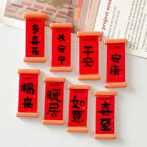 Detailed view of red resin scroll charms with embossed auspicious characters