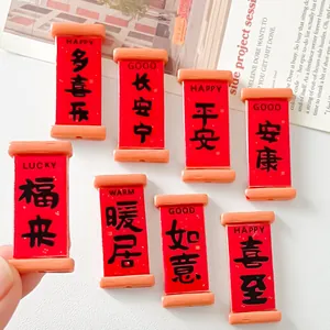 Detailed view of mini red resin scroll charms with Chinese lucky blessing characters