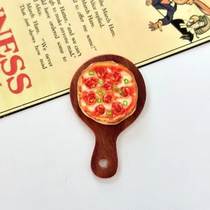 Dettaglio macro di una pizza in miniatura in resina su tagliere per casa delle bambole.