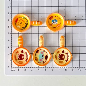 Close-up view of five miniature cartoon cat frying pan resin charms for DIY phone cases
