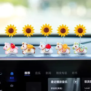 Dettaglio di mini ornamenti per auto a forma di pony con girasoli a molla sul cruscotto