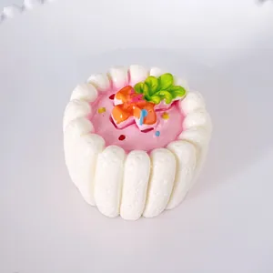 Nahaufnahme eines 3D-Kuchen-Kühlschrankmagneten mit rosa Glasur und Sahnetextur.