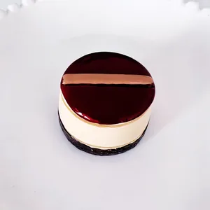 Detailaufnahme eines 3D-Miniatur-Kuchen-Kühlschrankmagneten mit roter Glasur und Cremeschichten