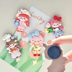 Detail of cute cartoon girl fridge magnets showing various designs and magnetic back
